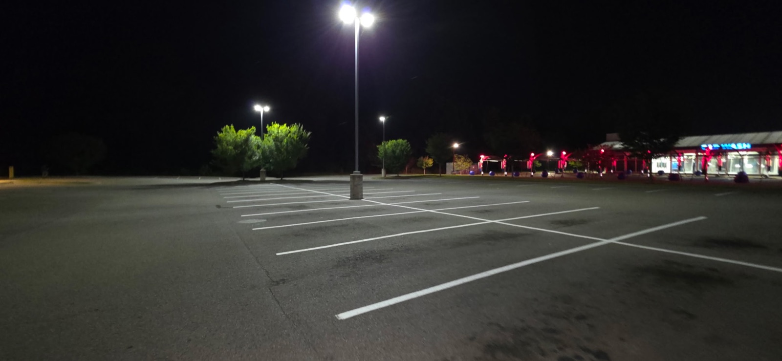 Fresh white parking lot striping completed at night at a Clarksville retail property